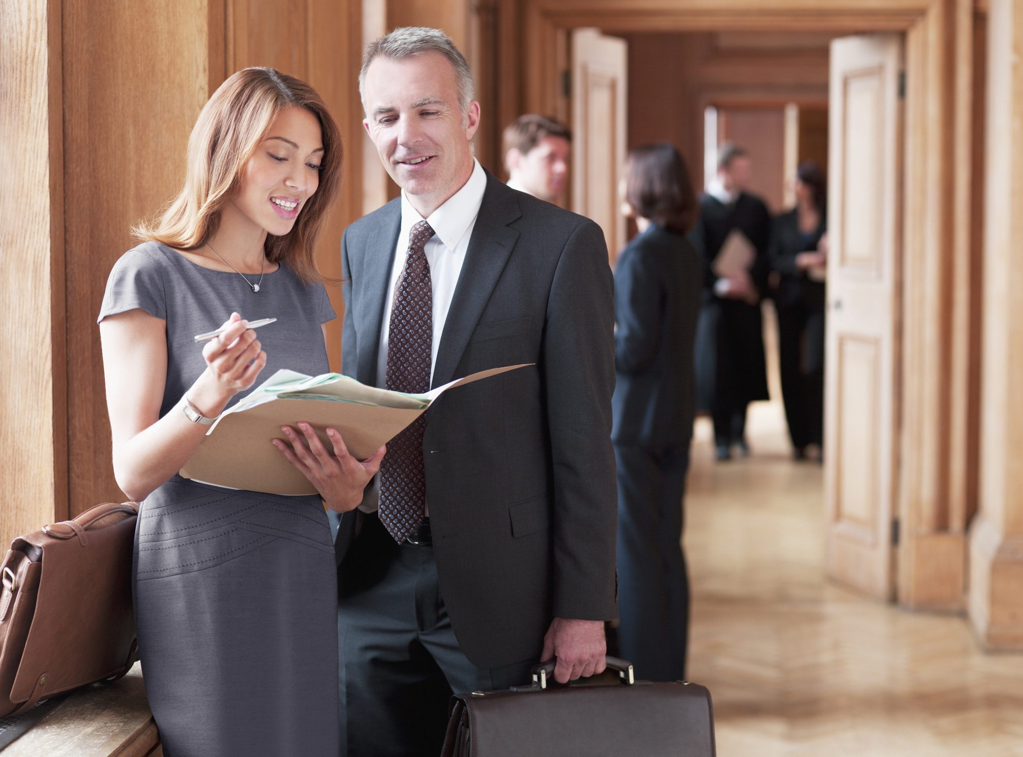 Business professionals reviewing documents in hallway