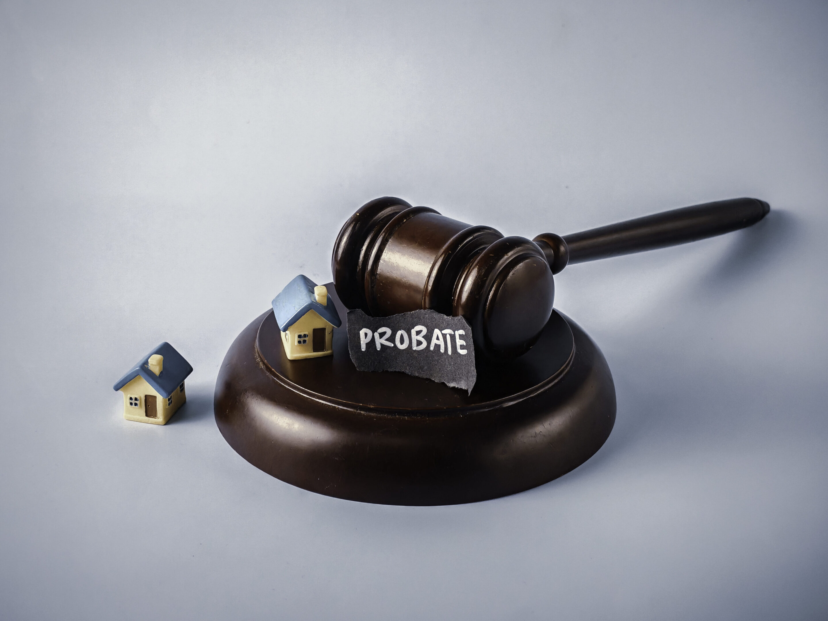 Probate Law Concept: Judge's Gavel, Miniature Houses, and Legal Paperwork Representing Estate and Will Administration